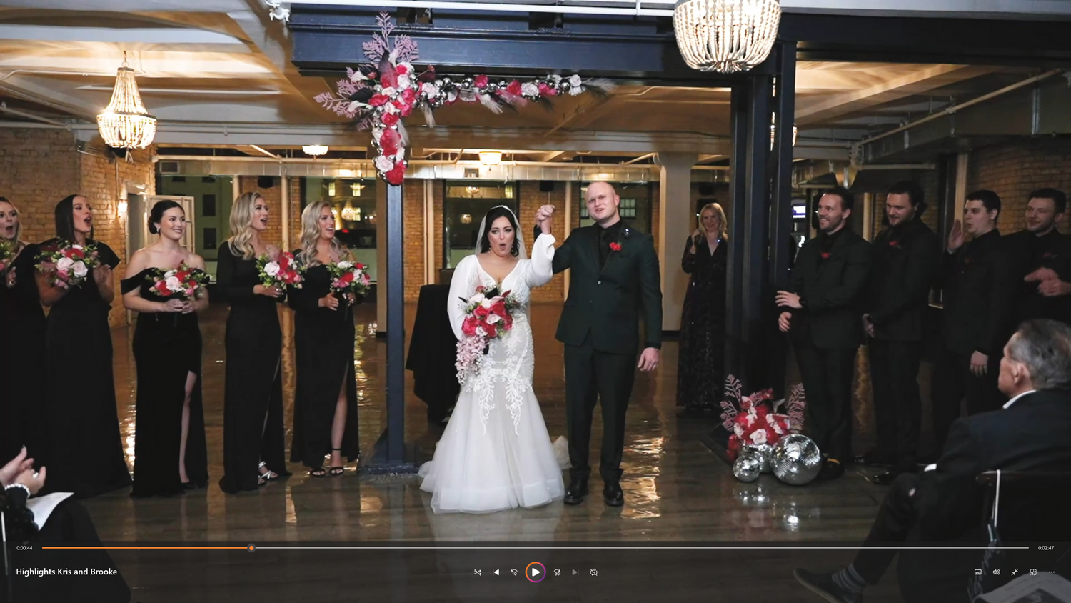 A newlywed couple smiles as they walk down the aisle together.
