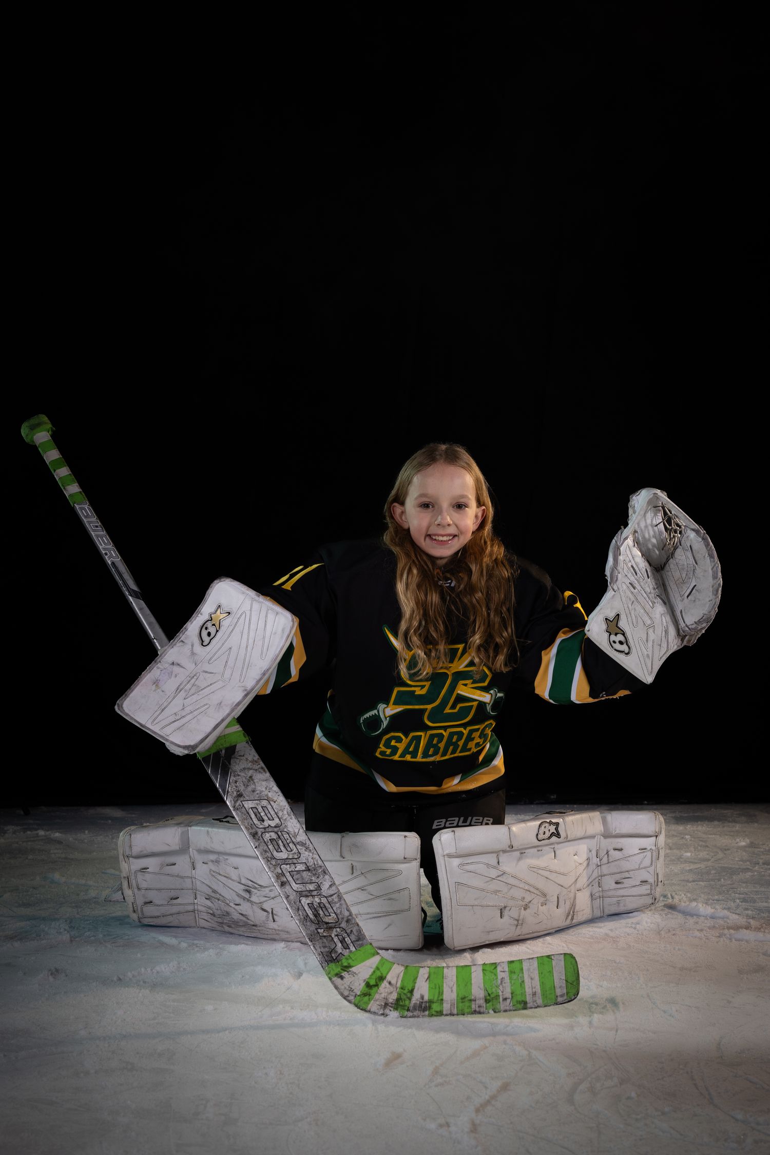 Stoney Creek Sabres Girls hockey goalie posing during on ice portrait session in Stoney Creek