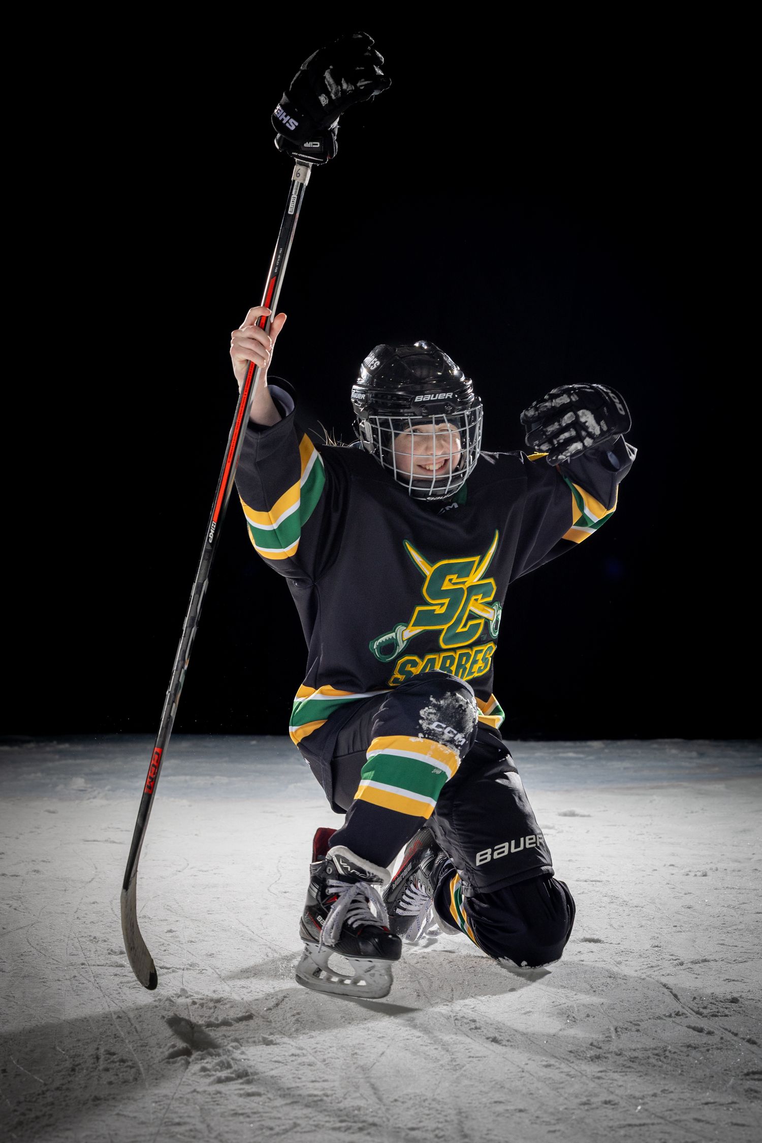 Stoney Creek Sabres Girls hockey player posing for a celly during on ice portrait session in Stoney Creek