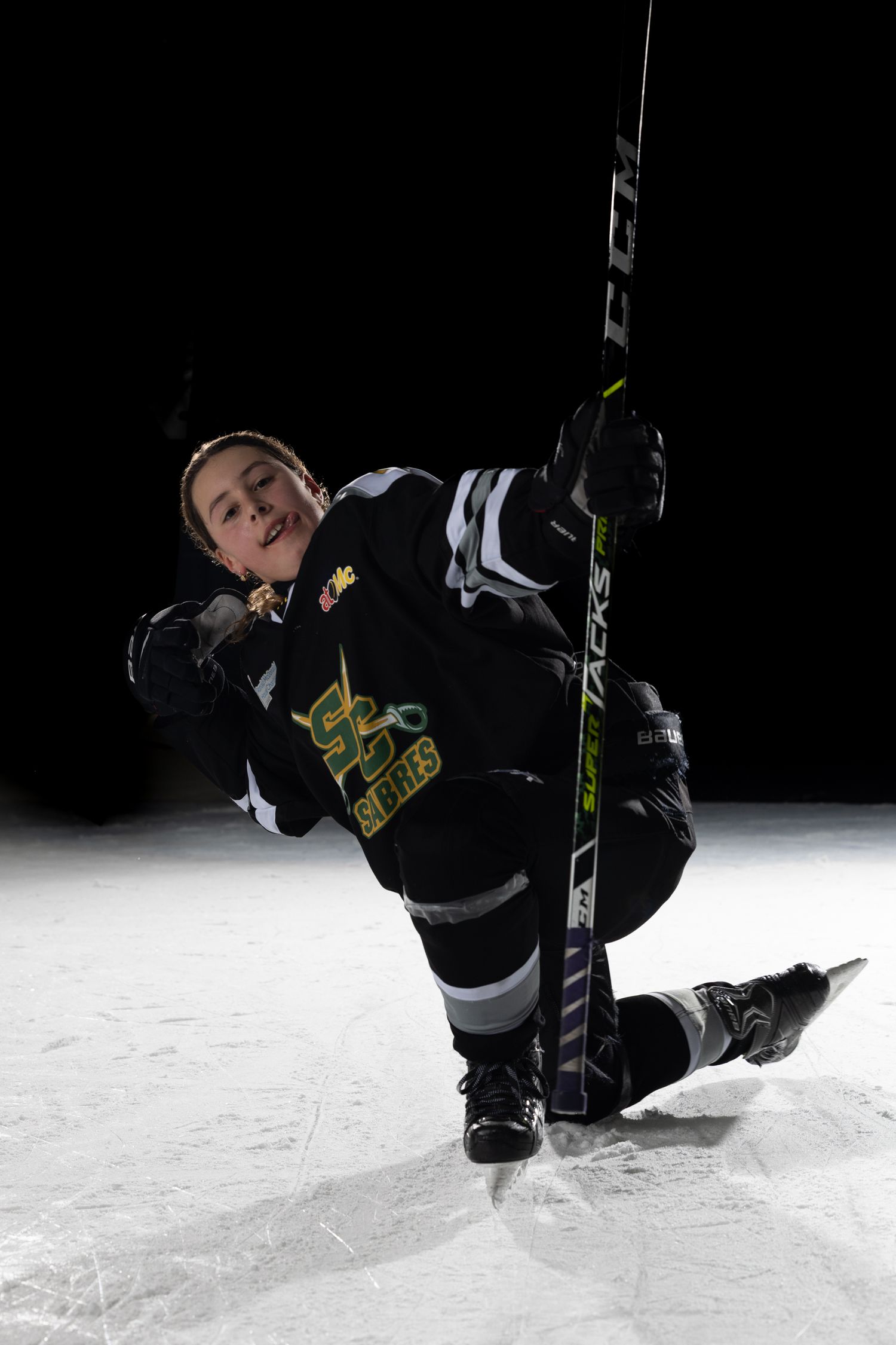 Stoney Creek Sabres Girls hockey player posing for a celly during on ice portrait session in Stoney Creek