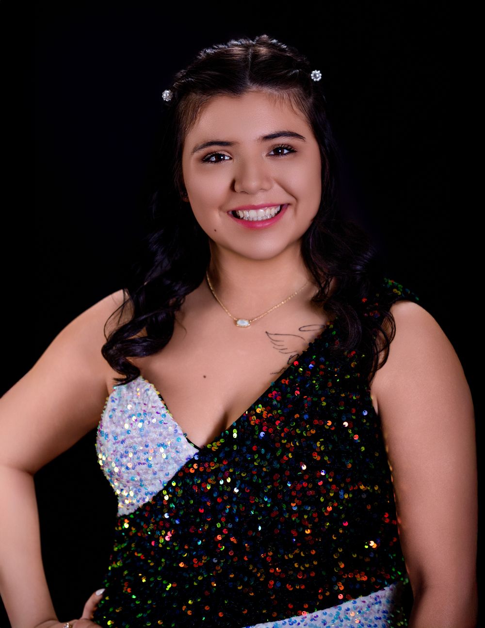 A sparkly black sequin dress with blue accents creates a dazzling fashion portrait series on a dark background.