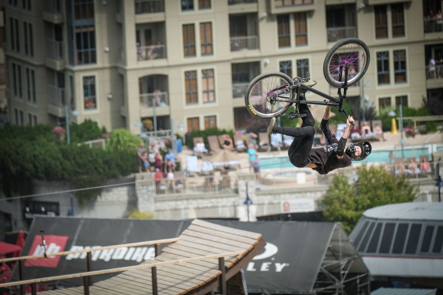 Extreme cyclist performs backflip over urban ramp with apartment building backdrop.
Whistler Mountain Bike Park
Crankworx