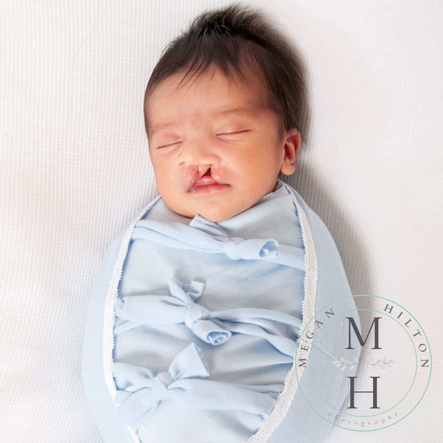 newborn boy wrapped in baby blue