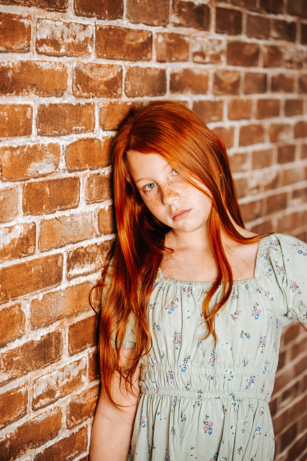 Portrait photography series against rustic brick wall background.