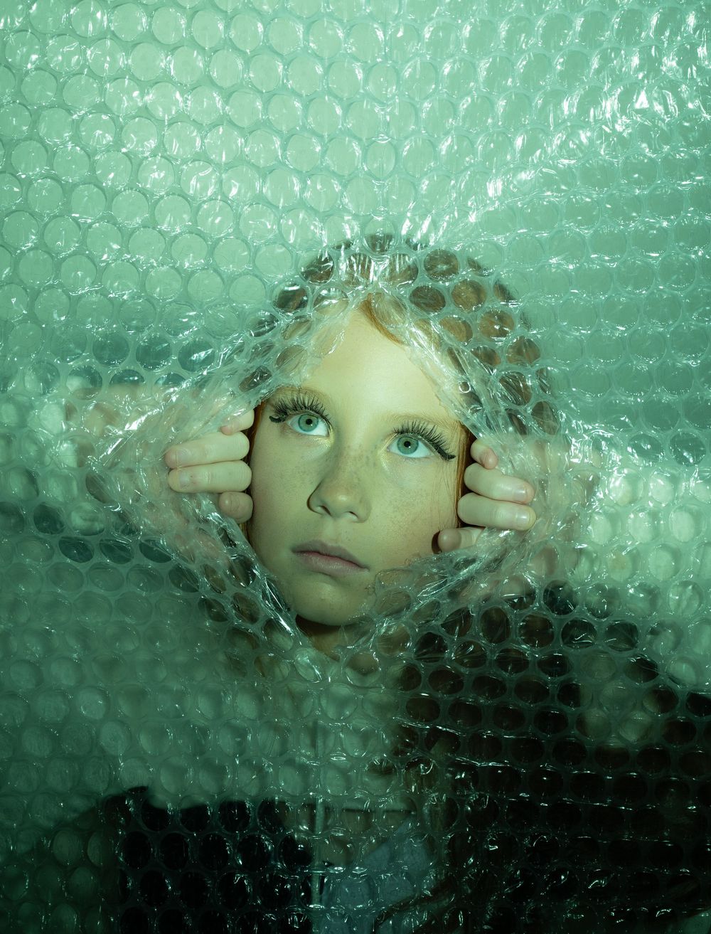 Abstract portrait through textured green bubble wrap creating an ethereal effect.