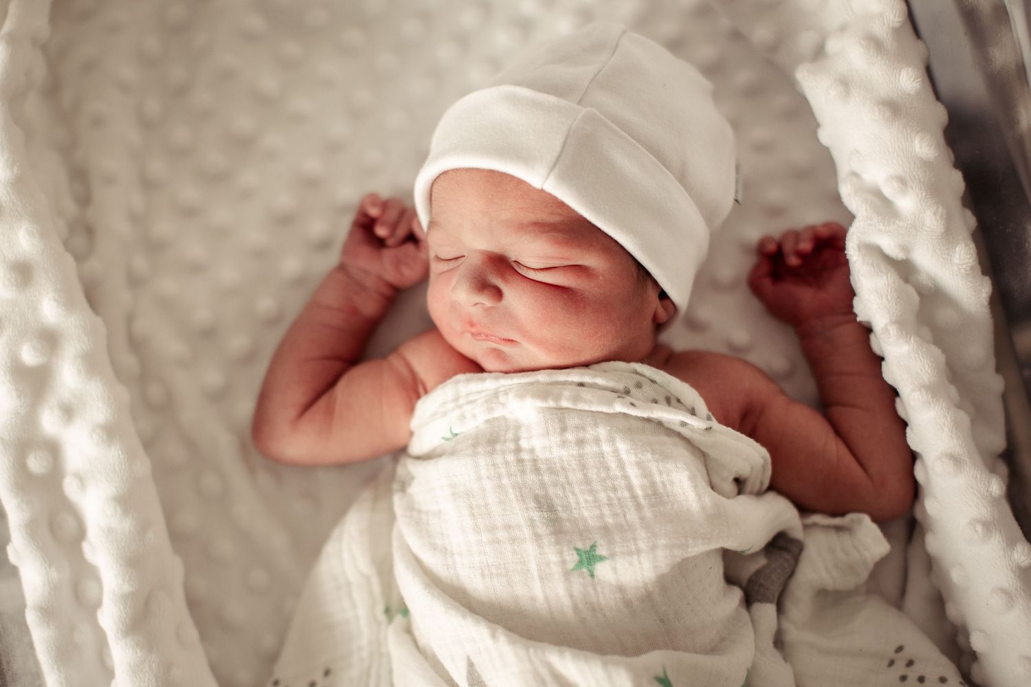 Black and white image of a sleeping newborn baby.