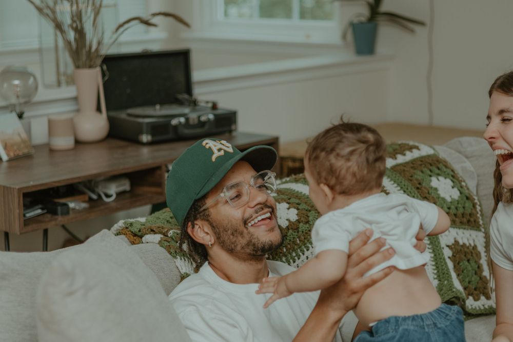 A playful moment of joy and laughter shared on a comfortable couch.