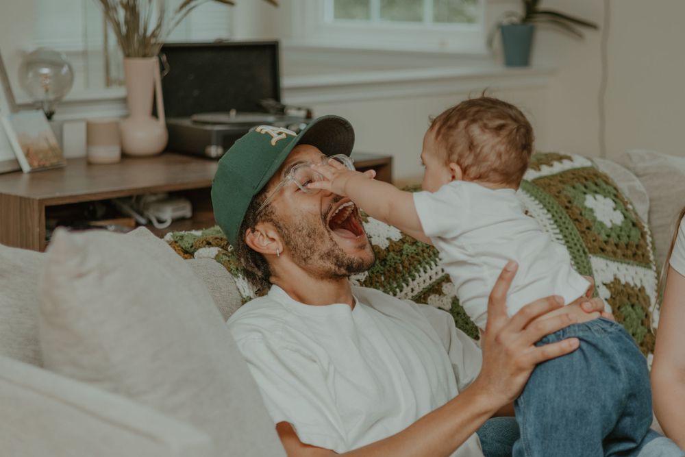 A heartwarming playtime scene with laughter in a sunlit living room.