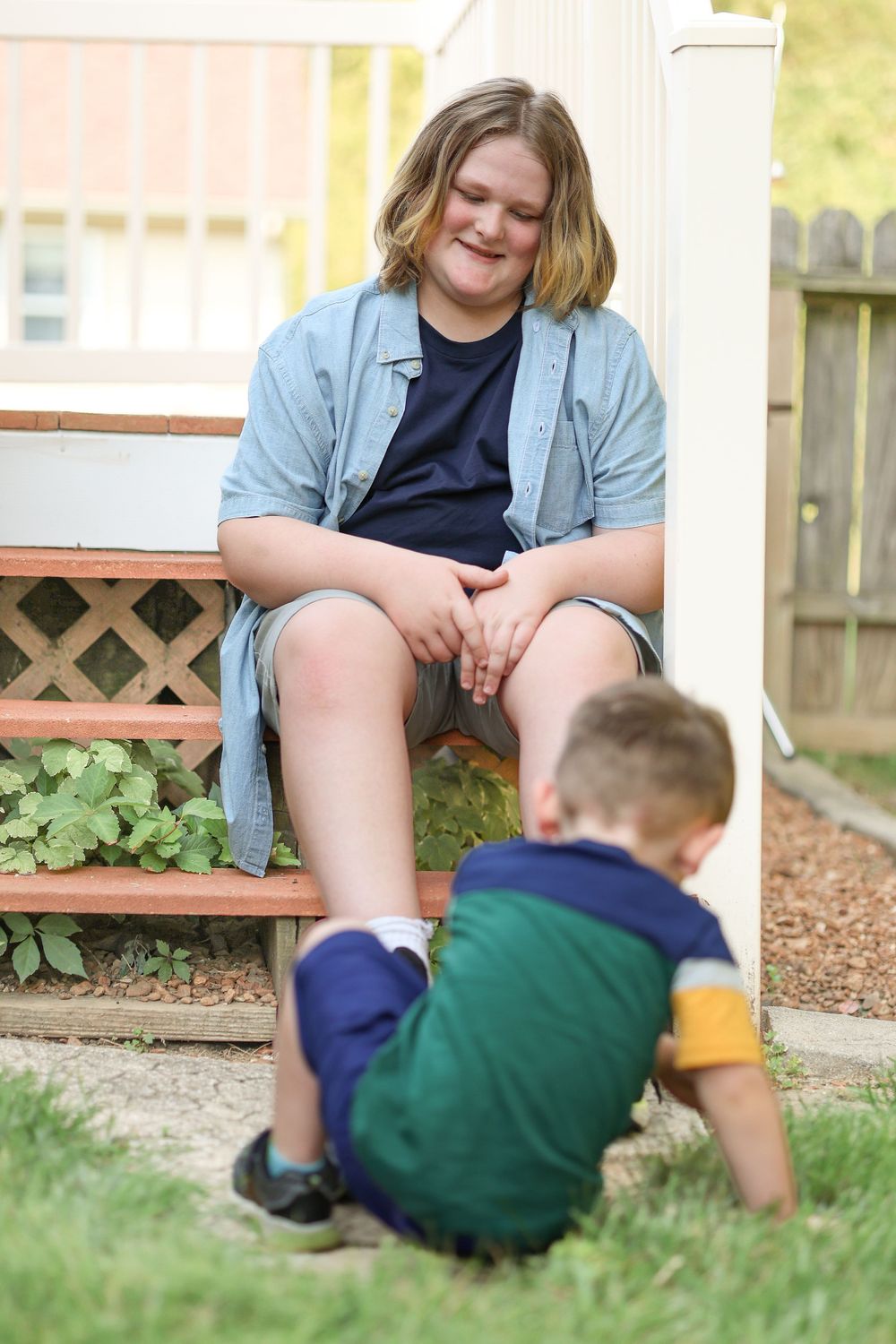 Casual outdoor scene on a wooden bench with plants and lattice in background.