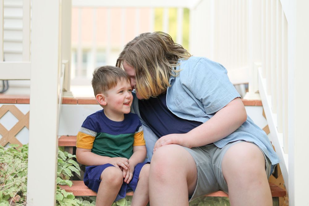 Sweet interaction between two people sitting on a porch bench.