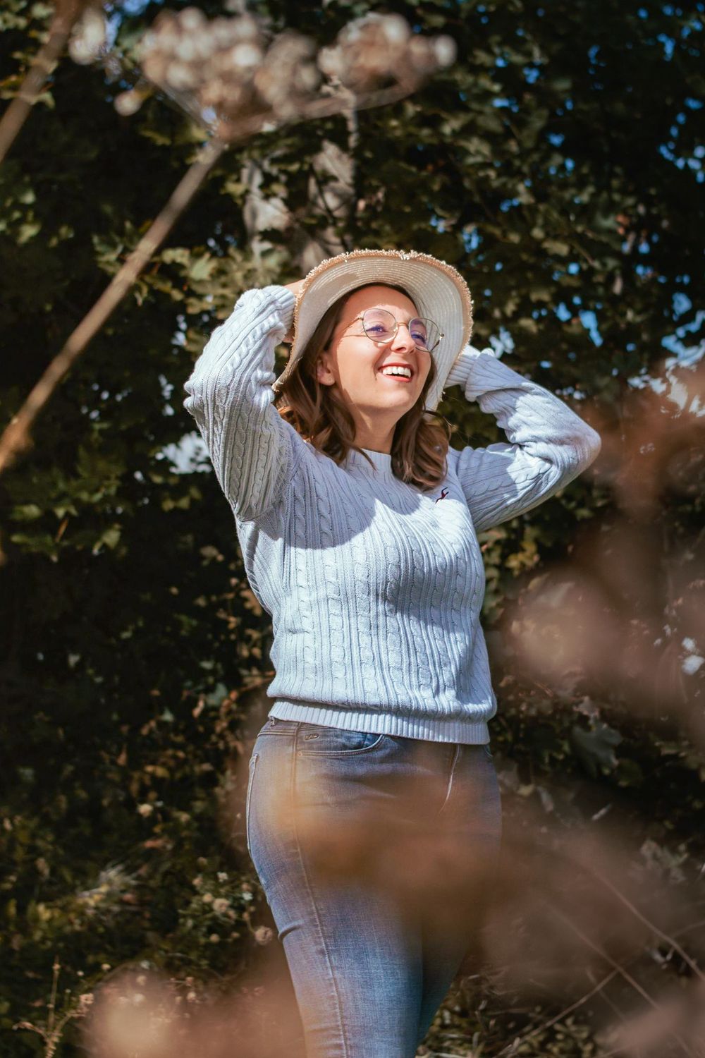Séance photo printanière avec Laure, capturée en extérieur avec des fleurs et une lumière douce, créant une atmosphère fraîche et naturelle.