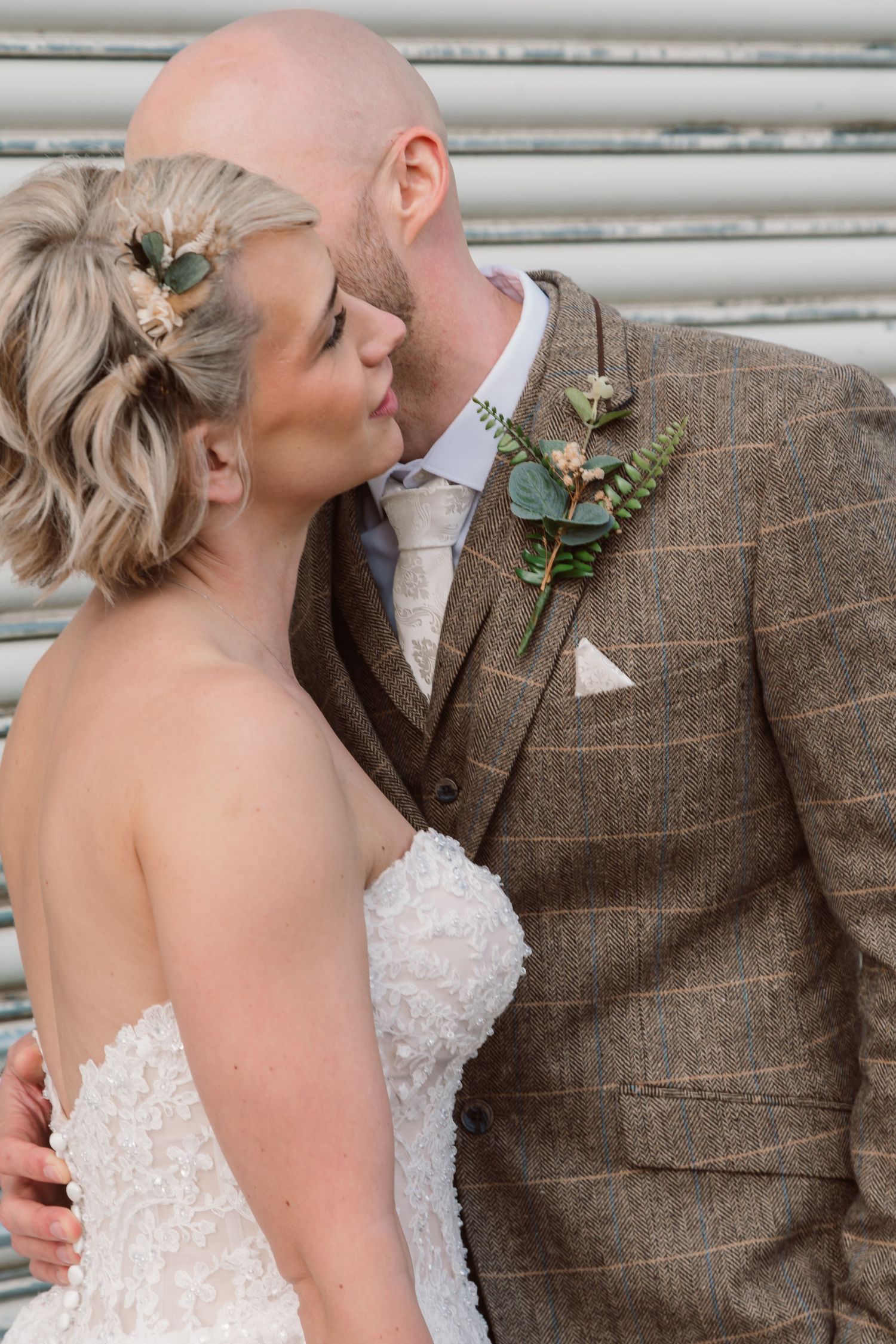 Romantic wedding portrait showing details of a lace dress and tweed suit against a light backdrop. Photographer. Hull. East Yorkshire. Photo