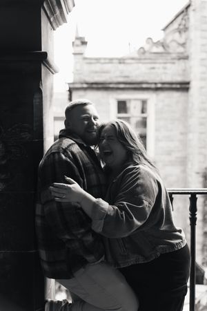 A romantic black and white photo sequence shows a couple in silhouette sharing an intimate kiss on a balcony.