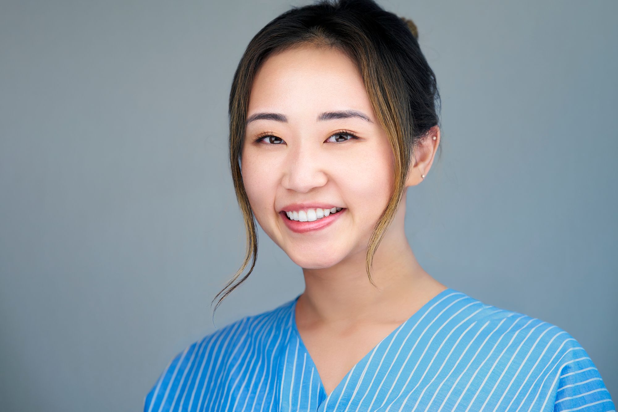 Professional studio portrait series in blue and grey tones showing joyful expressions and casual style.