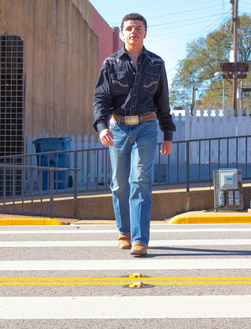 Person in denim jeans and jacket walking across a concrete surface with yellow curb markings in a series of action shots.