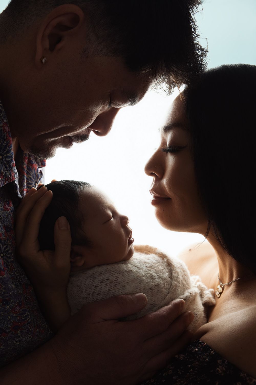 Artistic silhouette portraits showing intimate family moments in dramatic backlit style.