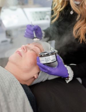 Lincoln, Illinois Aesthetician applies face mask during facial for a professional branding session by Julie Loy Photography