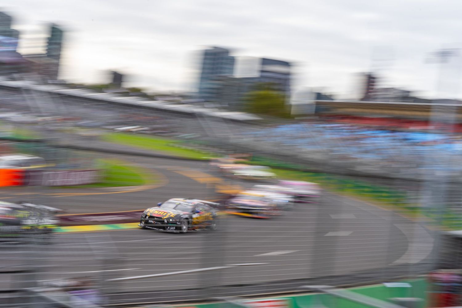 Race cars competing on a street circuit with motion blur effect.