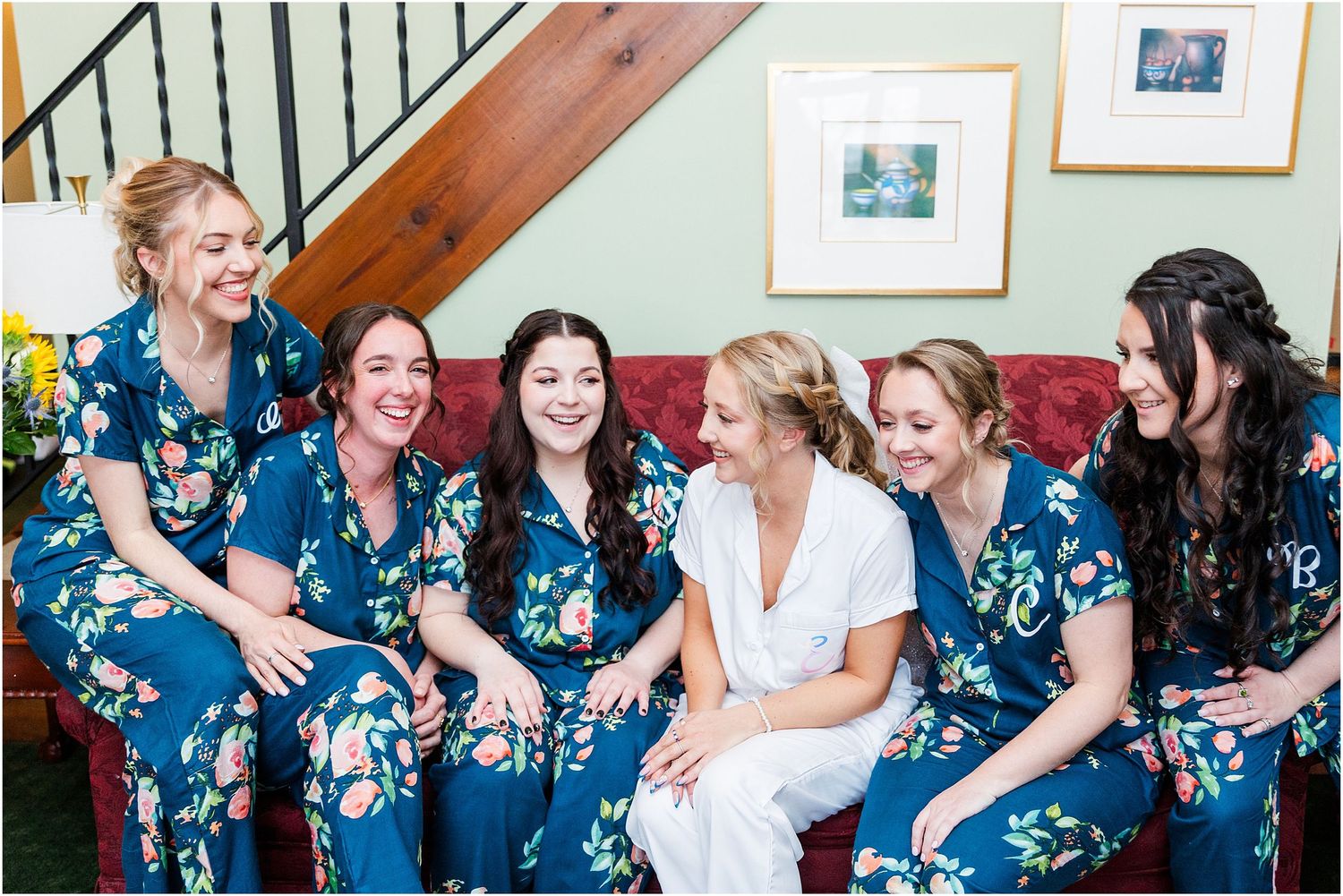 Candid moment of bridal party laughing together while wearing matching blue floral robes.