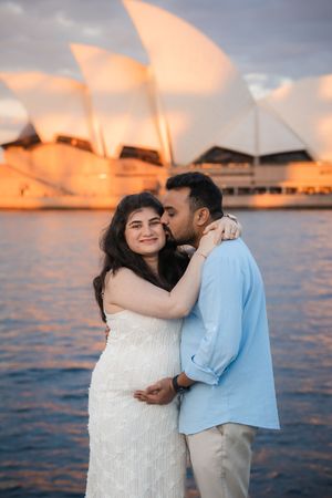 A romantic maternity photoshoot against the Sydney Opera House during golden hour.