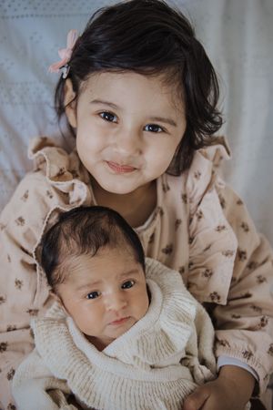 A series of tender moments captured in soft, muted tones showing siblings in matching beige outfits.