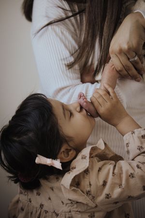 A tender moment between parent and child as they share a playful interaction in soft natural lighting.