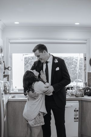 A romantic sequence of black and white photos showing a couple in formal attire sharing intimate moments in a bright interior space.