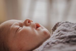 Close-up shot of peaceful sleeping baby on soft blanket.