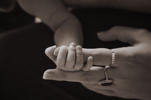 Series of black and white photos showing delicate newborn baby feet cradled in caring hands.