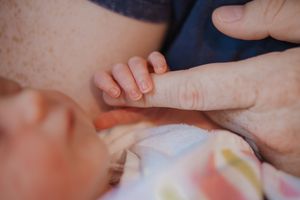 A close-up sequence showing a baby's tiny fingers and toes in soft natural lighting.