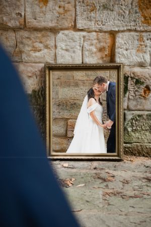 A creative bridal portrait series reflected in vintage frames against a rustic stone wall.