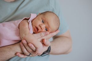 A collage of tender newborn photography moments captured in soft pink and neutral tones.