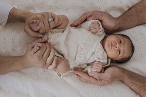 A series of tender moments showing parent and baby lying together on white bedding.
