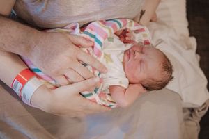 A series of photos showing a newborn baby being gently swaddled in a soft pink and white blanket.