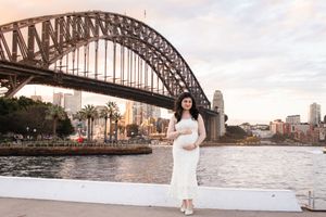 Scenic view of Sydney Harbour Bridge with city skyline and waterfront during golden hour.