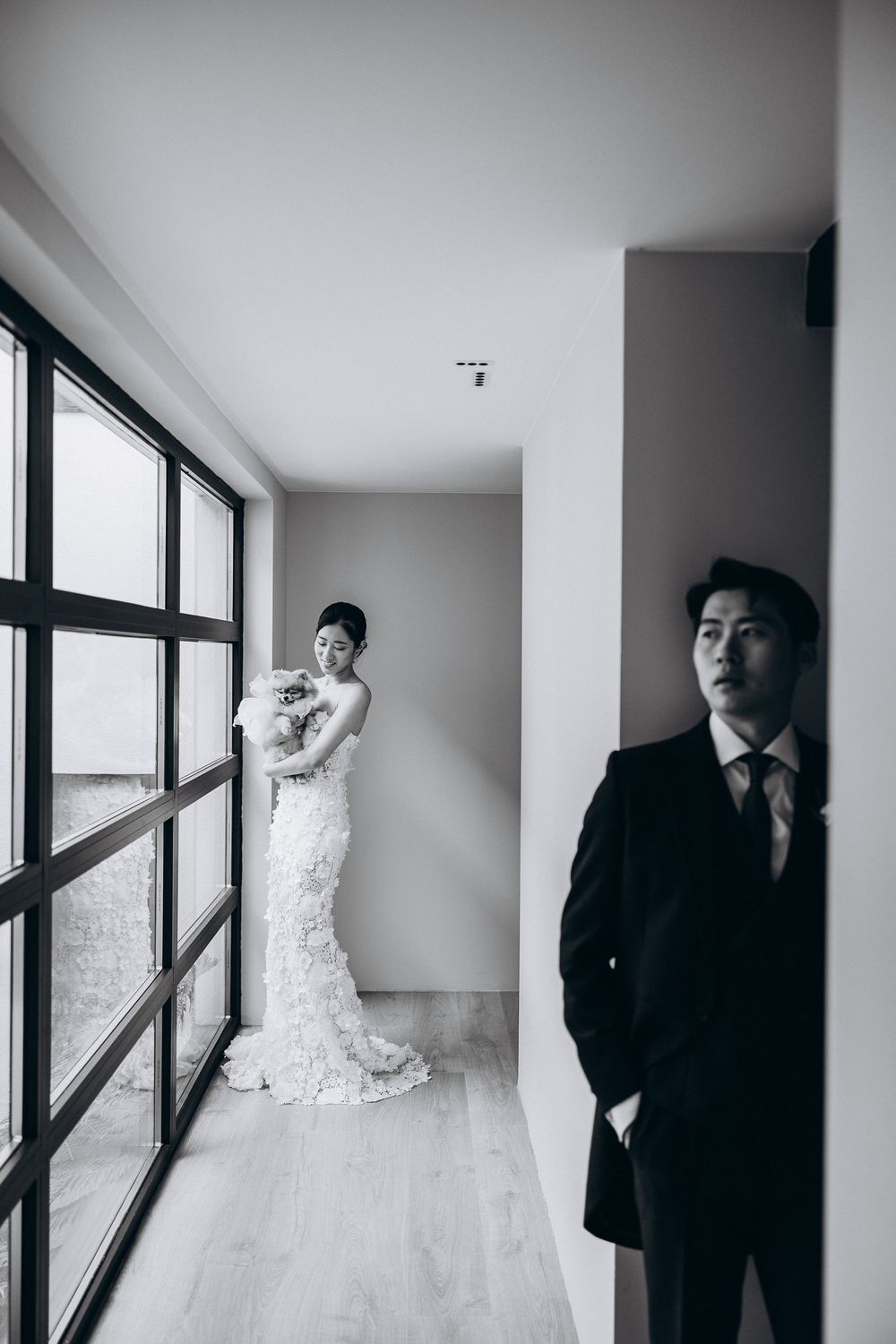 Black and white wedding photo series featuring a hanging bridal gown and formal attire.