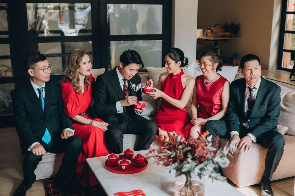Wedding party members in red dresses and black suits gather for celebratory moments.