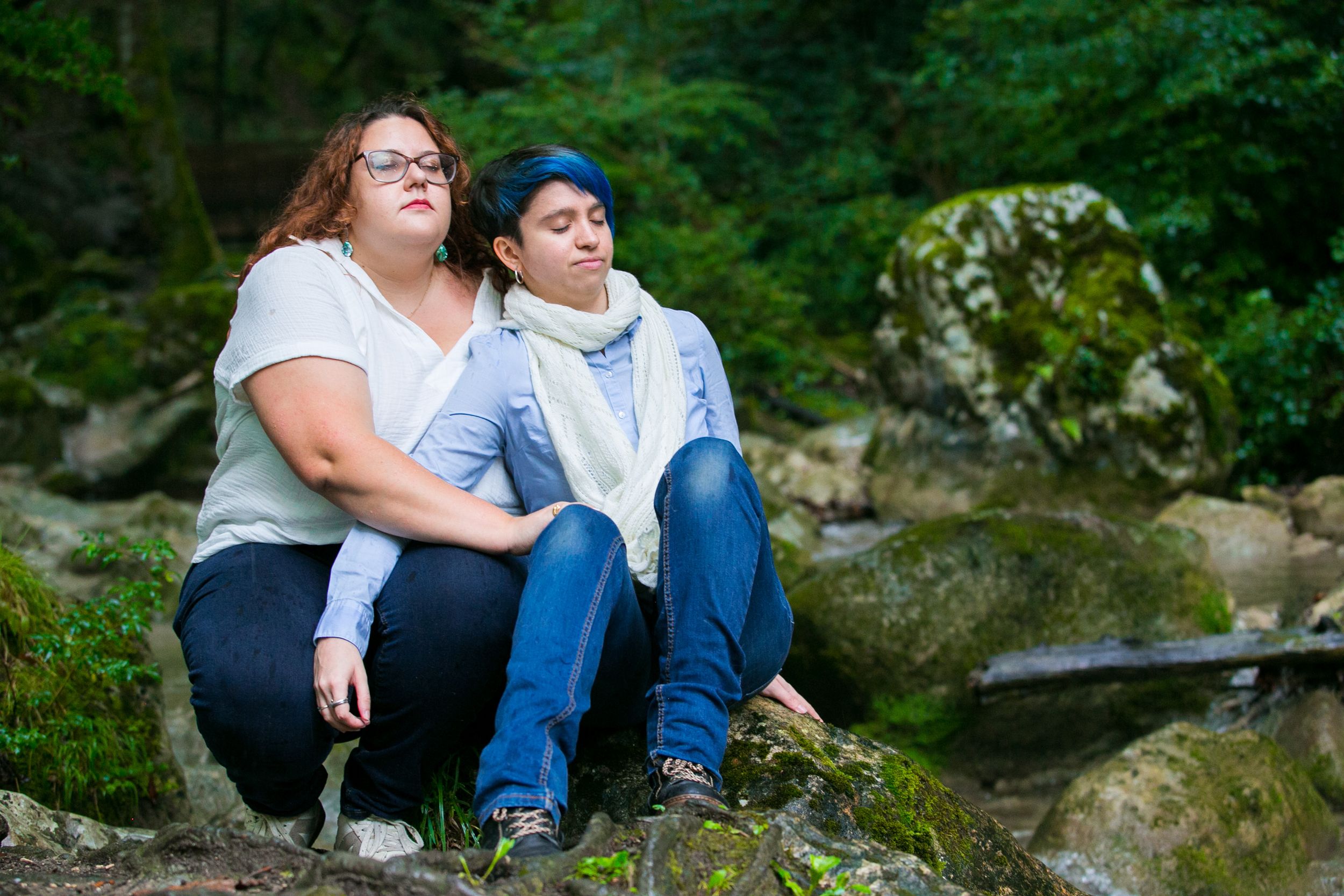 Un couple de femmes enlacées au bord d'un ruisseau à Saint Vincent-de-Mercuze, lors d'une séance photo d'engagement.