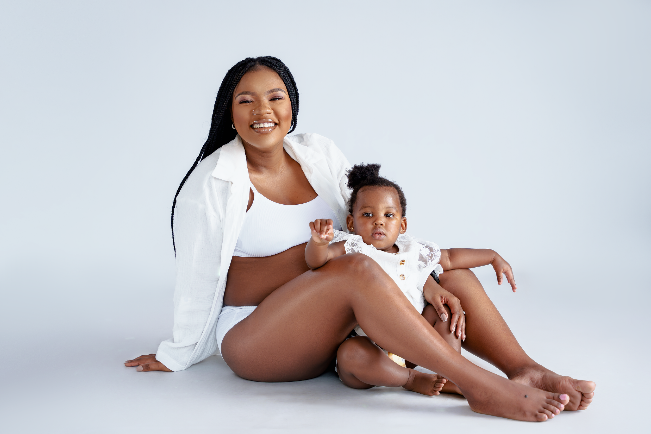 Mother and young child pose together during intimate maternity photoshoot.