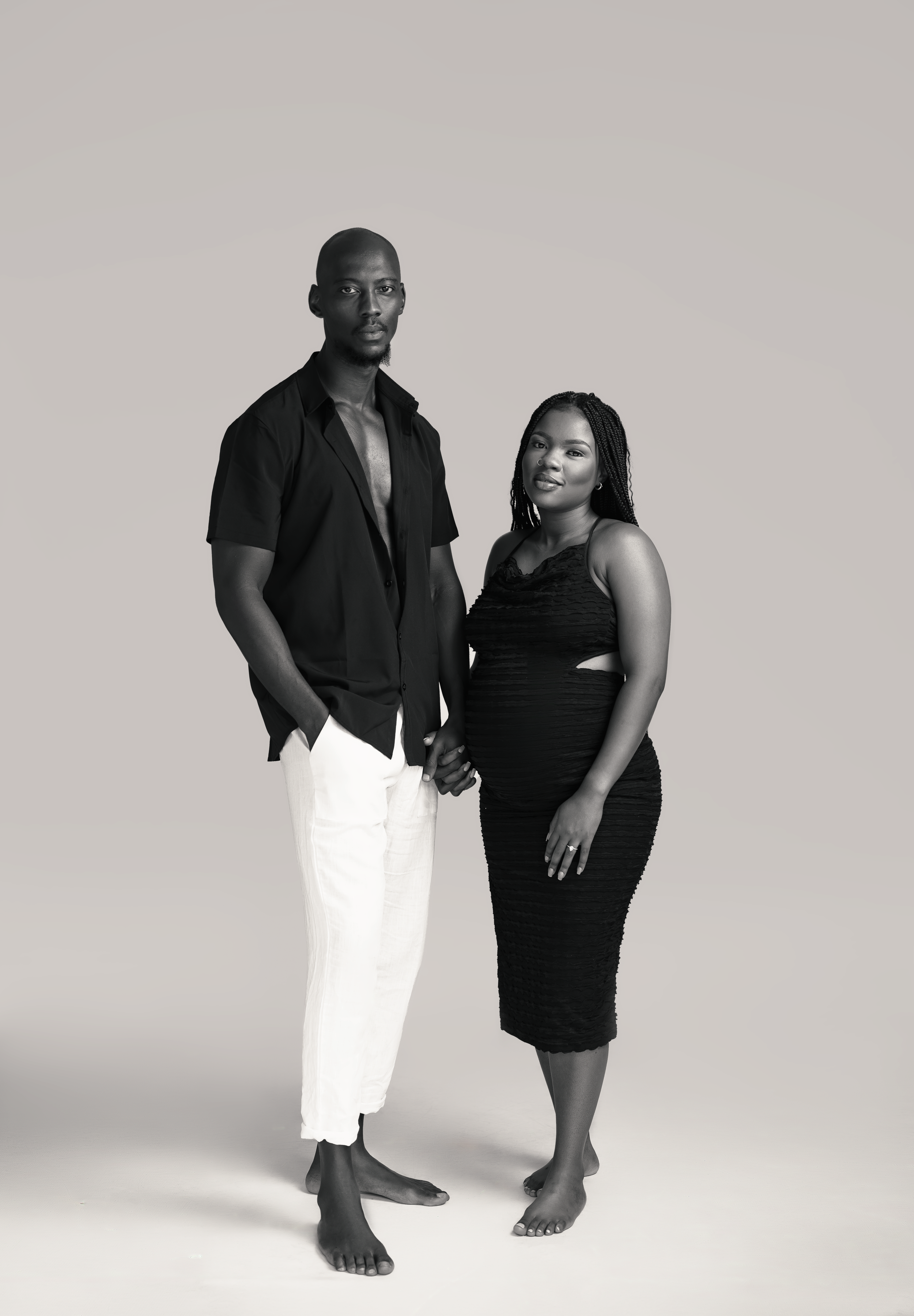 Elegant black and white full length portrait of couple in contrasting outfits.