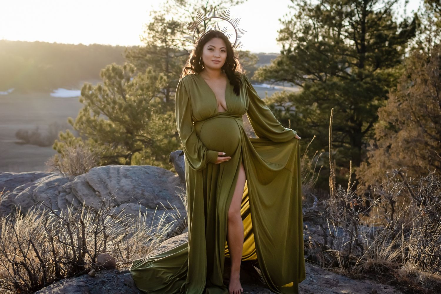 maternity photography of a pregnant mother wearing a green gown and holding her belly