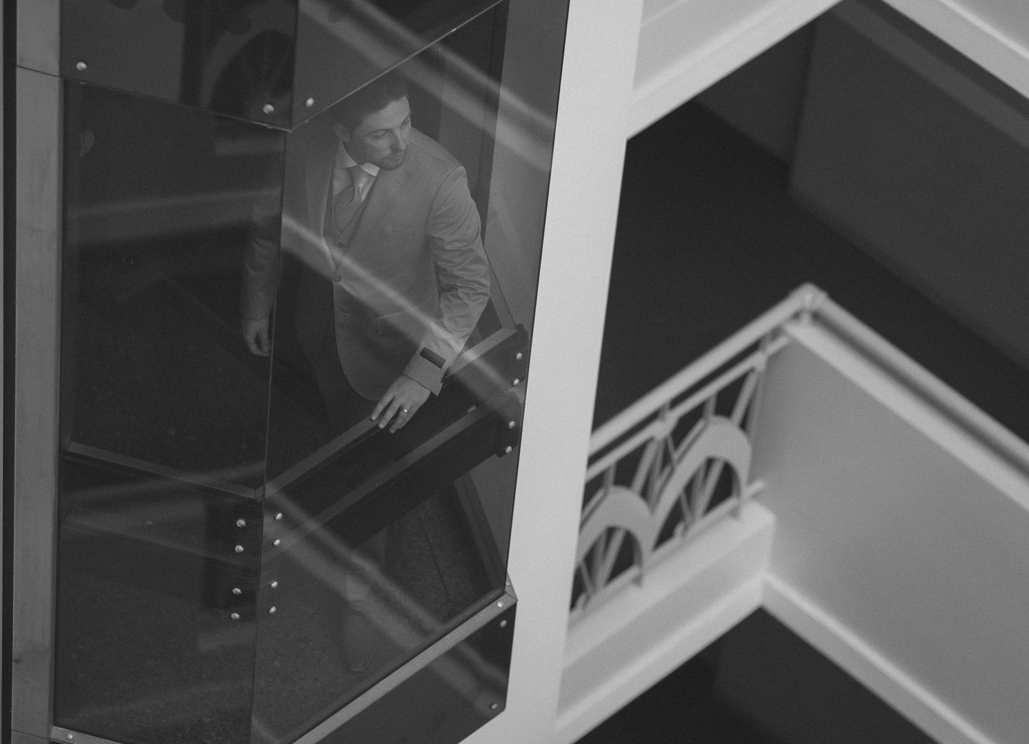 Artistic black and white architectural shot showing figure through geometric patterns.