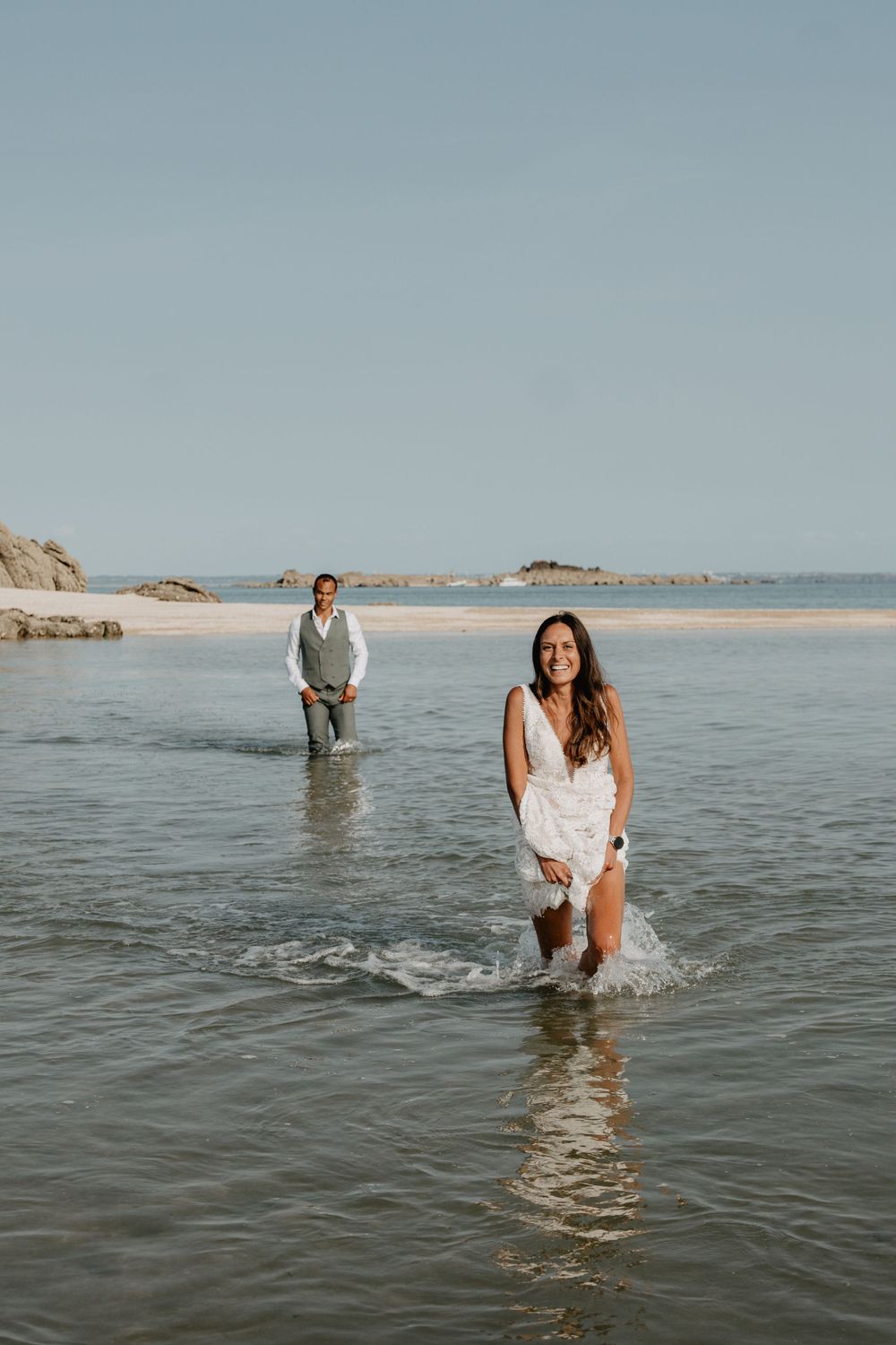 mariée qui marche dans l'eau sur un banc sur les îles Chausey