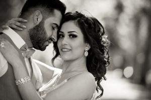 An intimate black and white close-up of a romantic couple in wedding attire.