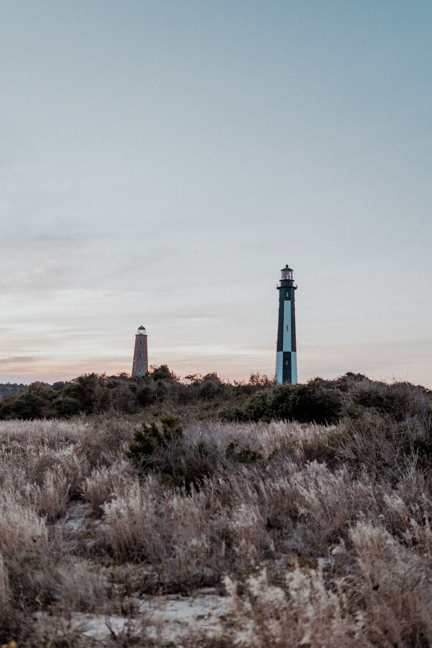 Fort Story Beach and cape henry lighthouse in Virginia Beach, Virginia at sunset