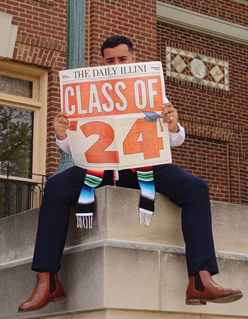 Close-up of navy blue pants and brown boots with Class of 24 sign.