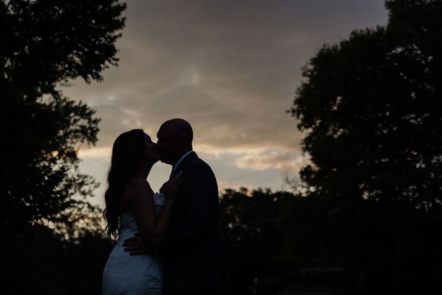 A couple sits together in a church pew with a candelabra visible in the background during an intimate ceremony.