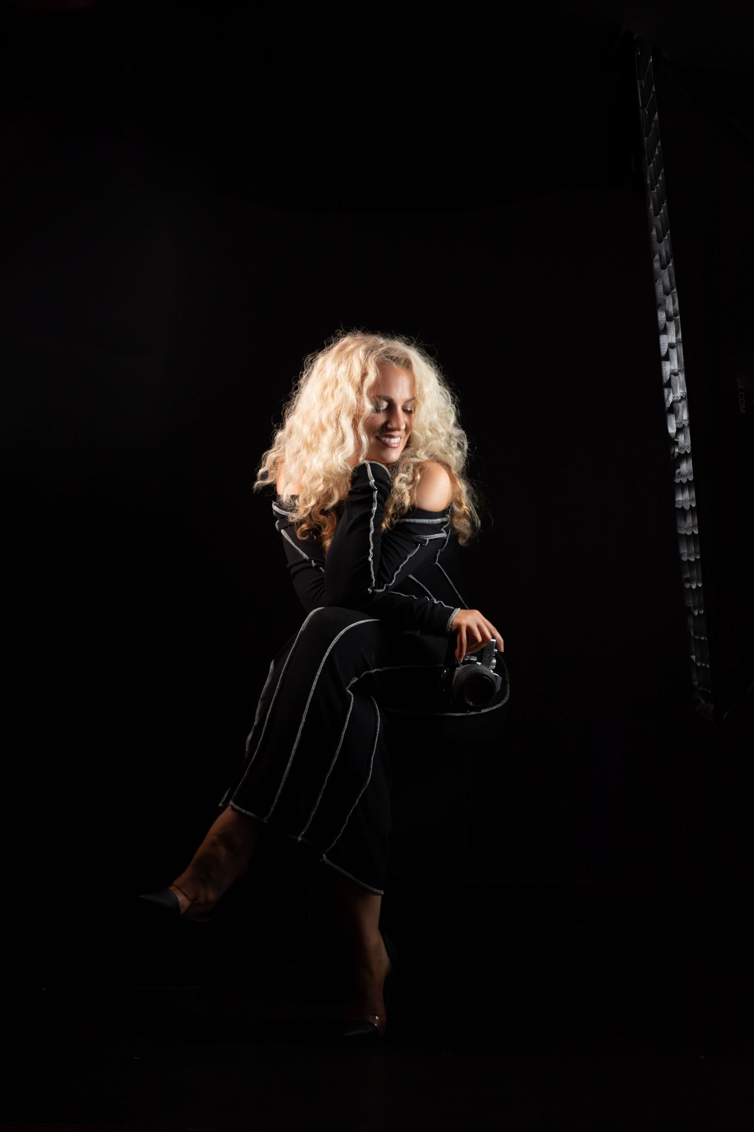 A dramatic artistic portrait of a figure in black against a dark background with flowing blonde hair at E.A. Larkins Photography Akron Ohio.