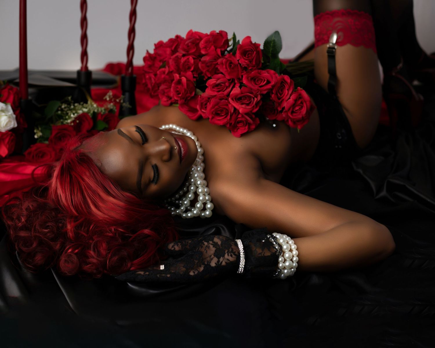 Artistic boudoir photo with dramatic red roses and pearl jewelry against dark background at E.A. Larkins Photography Akron studio.
