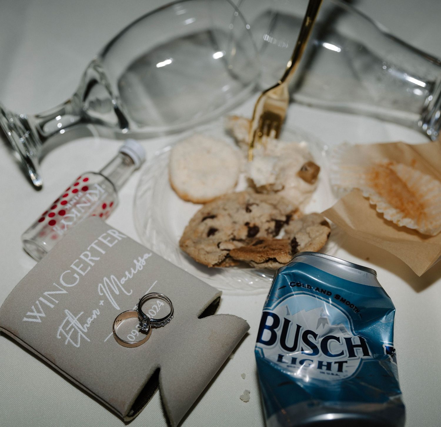 spills create an artistic pattern on white paper with a wedding ring and writing visible in soft lighting.